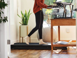 Woman walking on a treadmill at a workstation