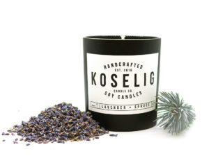 candle with sprig of pine and pile of seeds