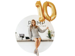 Wesley Uthus sitting on a table holding a number ten balloon