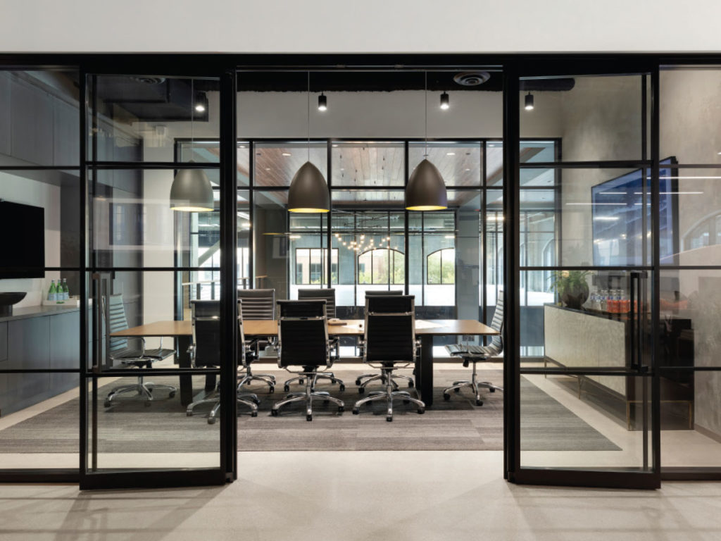 Floor-to-ceiling acoustic glass panels soundproof the main conference room.