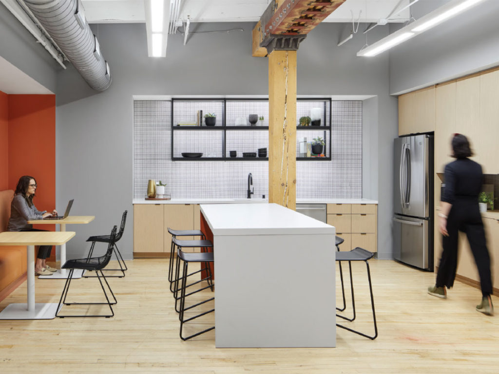 In one of the larger suites, the cabinetry connects to the building’s birch and maple floors. The burnt-orange built-in is a custom feature that expands the entry into a social space. 