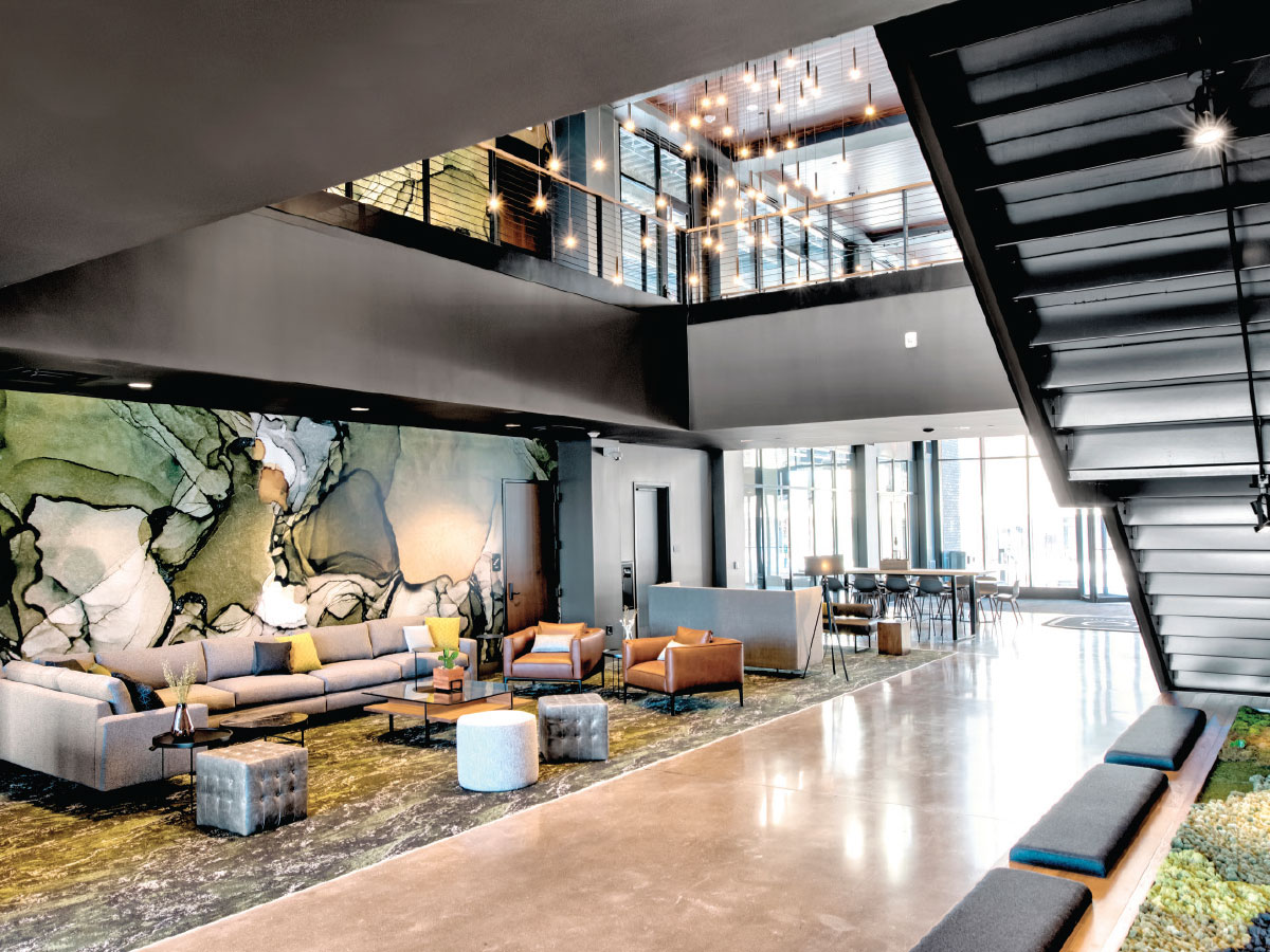 A two-story watercolor mural and a moss garden beneath the stairs add warmth to the industrial modern design. 