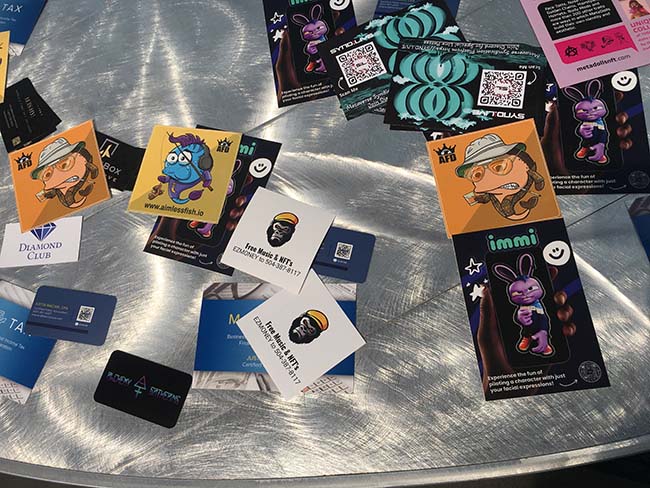 A table advertising various types of NFTs at VeeCon.