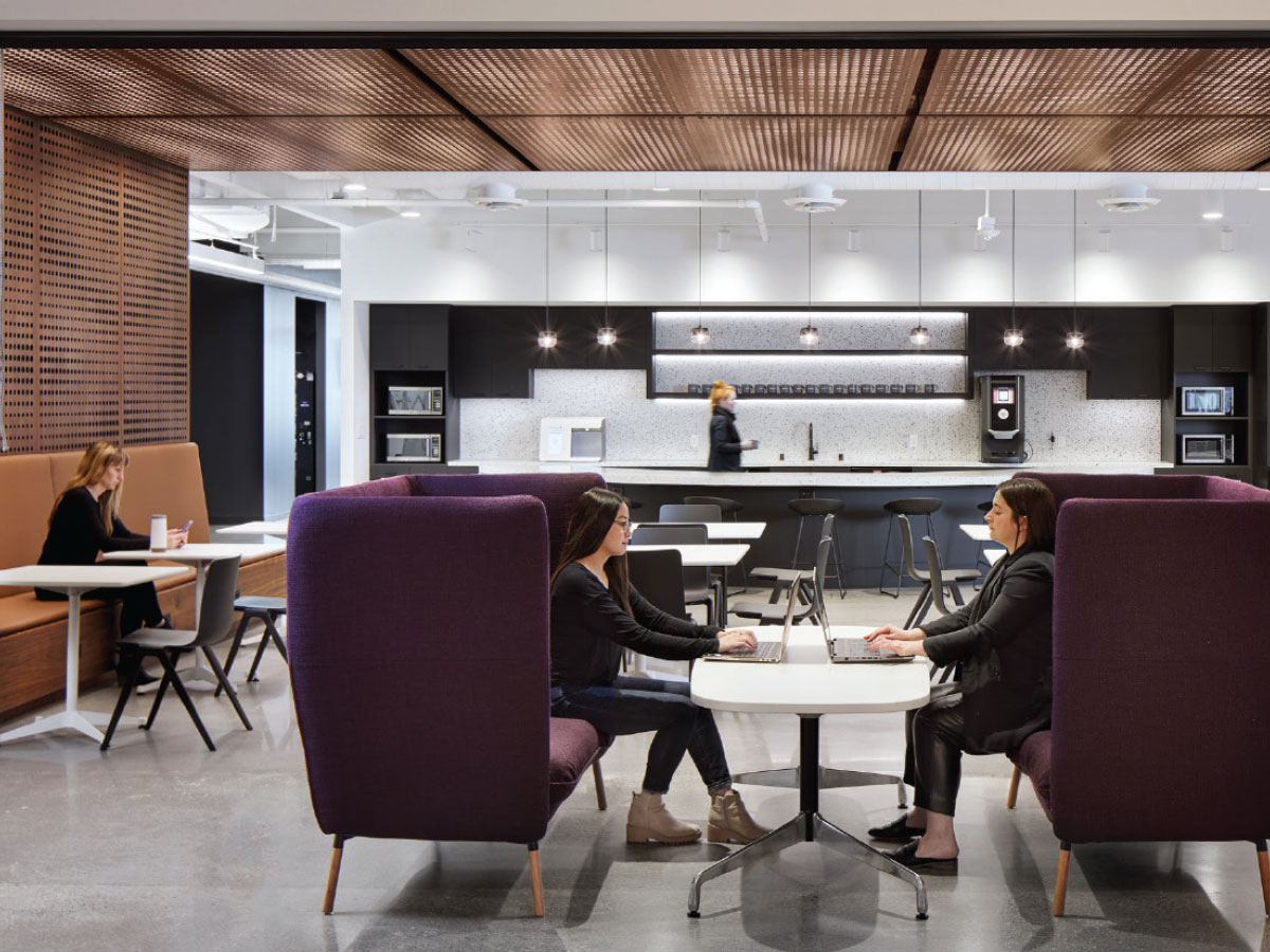 A three-dimensional patterned walnut screen separates the café space from the adjacent hallway. A garage door connects the lobby to the café.