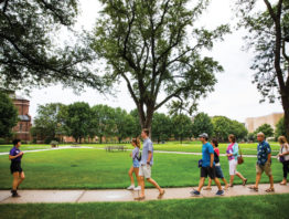 Tour guide Divine Zheng leads a group through the upper quad at the University of St. Thomas.