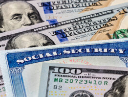 Social Security cards atop 100-dollar bills