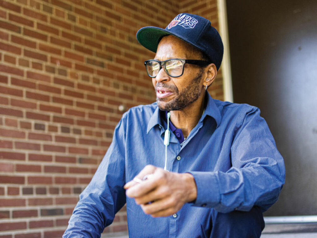 man sits on steps out side of door