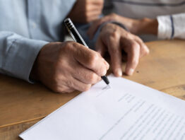 photo of man signing a legal document