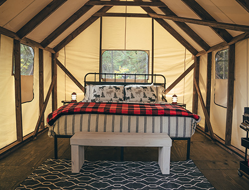 Interior of North Shore Camping Company site, which includes a bed and furniture.