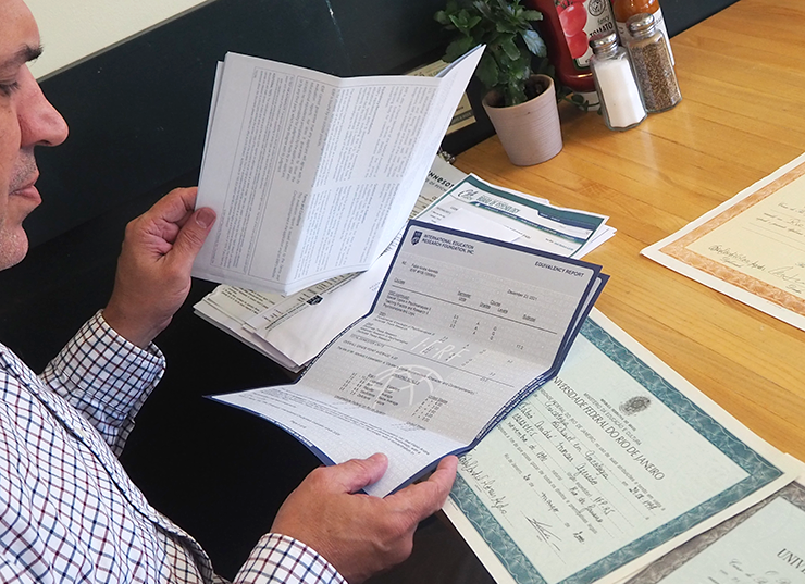 Azeredo shown looking over the many documents he has had to assemble to argue his case for licensure with the Minnesota Board of Psychology.