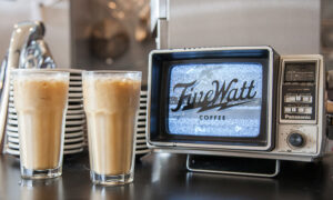Two iced coffee drinks next to an old-school television set at Five Watt Coffee