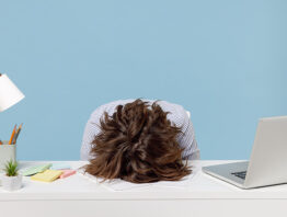 Exhausted worker with head down at desk