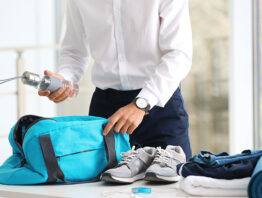 Businessman packing gym stuff into bag in office