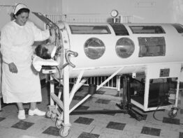 A nurse caring for a polio patient inside an Emerson respirator, also known as an iron lung machine, in 1960.