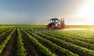 Tractor spraying pesticides on soy field with sprayer in the spring.